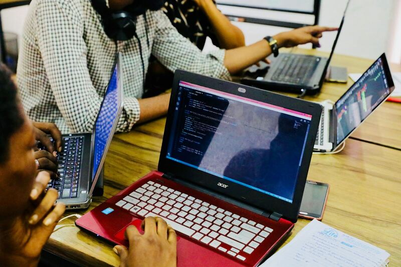 A developer writing code on a laptop